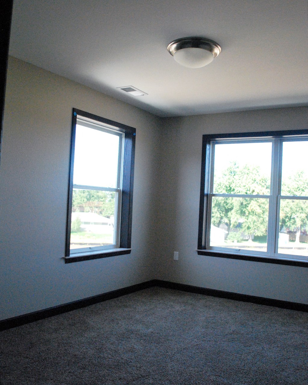 an empty room with two windows in it