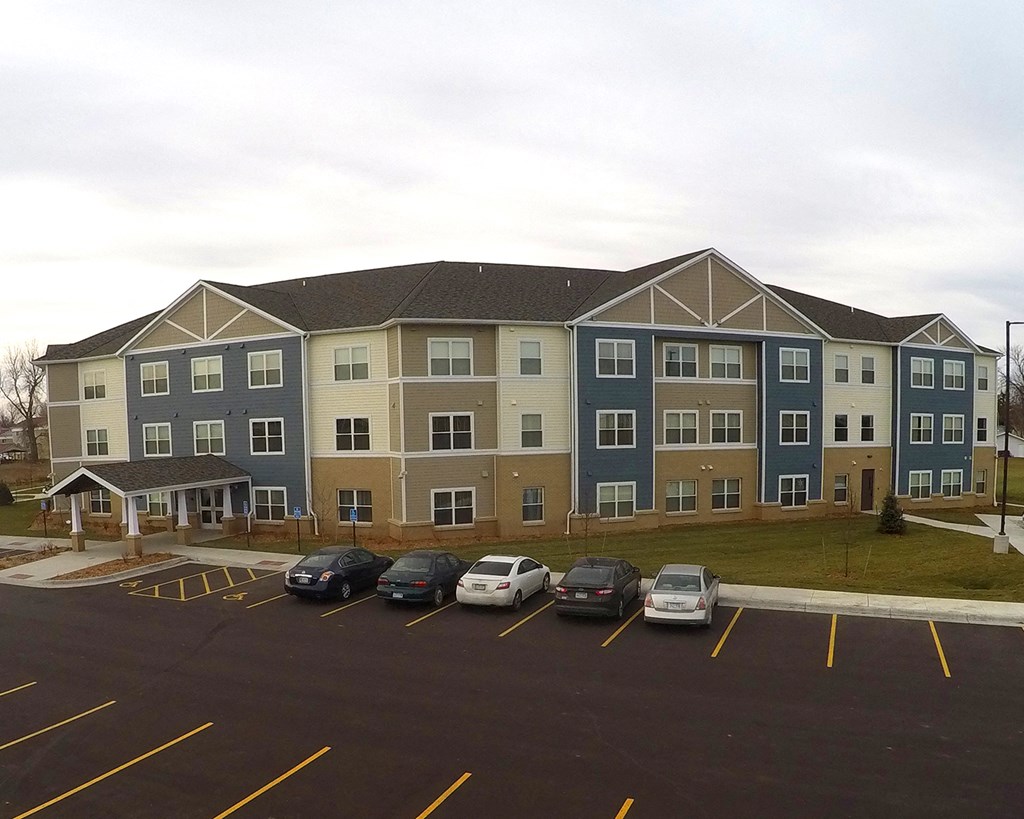 an apartment building in a parking lot with cars