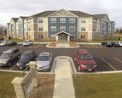 a parking lot with cars in front of an apartment building