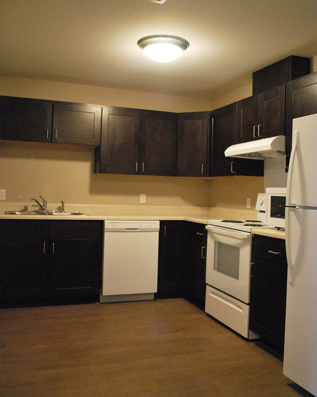 a kitchen with white appliances and black cabinets
