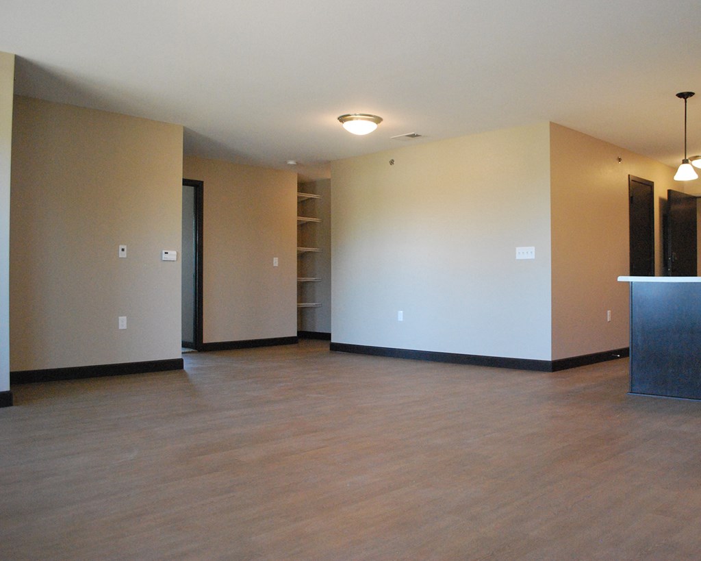 the living room of an empty apartment with a wooden floor
