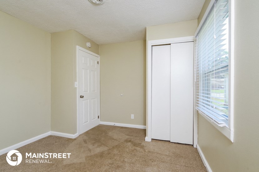 a bedroom with a large window and a white door