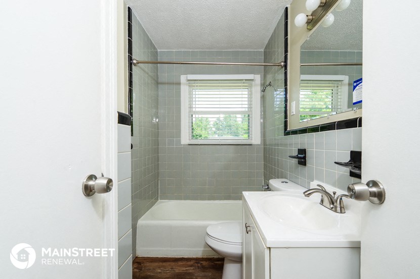 a small bathroom with a sink toilet and a bath tub