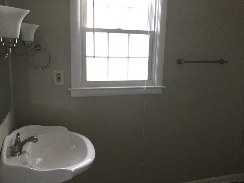 a bathroom with a white sink and a window