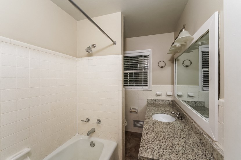 a bathroom with a tub and a sink and a mirror