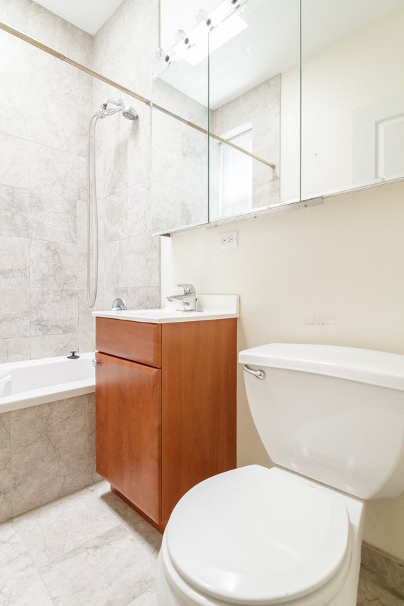 a bathroom with a toilet and a tub and a sink