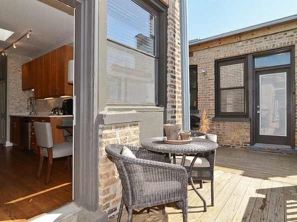 a patio with a table and chairs and a window