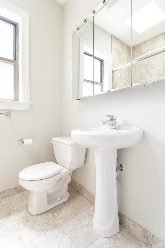 a bathroom with a toilet and a sink and a mirror