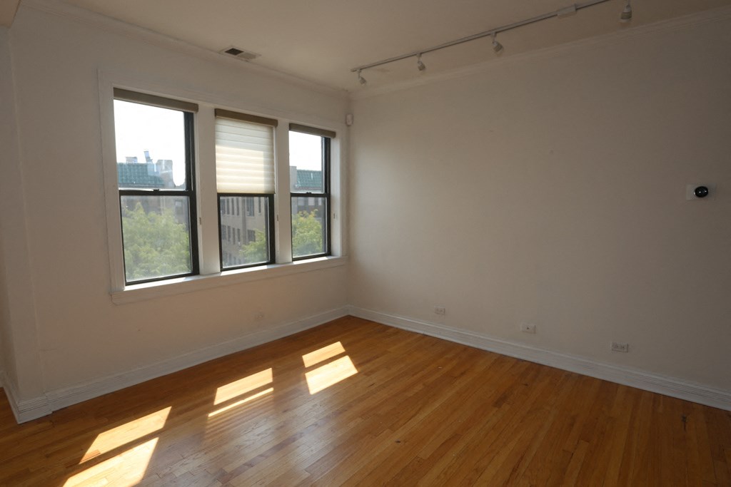an empty living room with wood floors and windows
