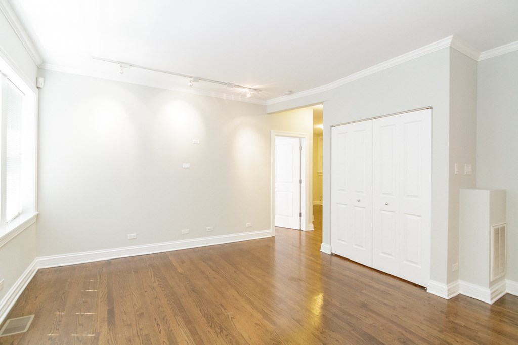 an empty living room with white walls and wood floors