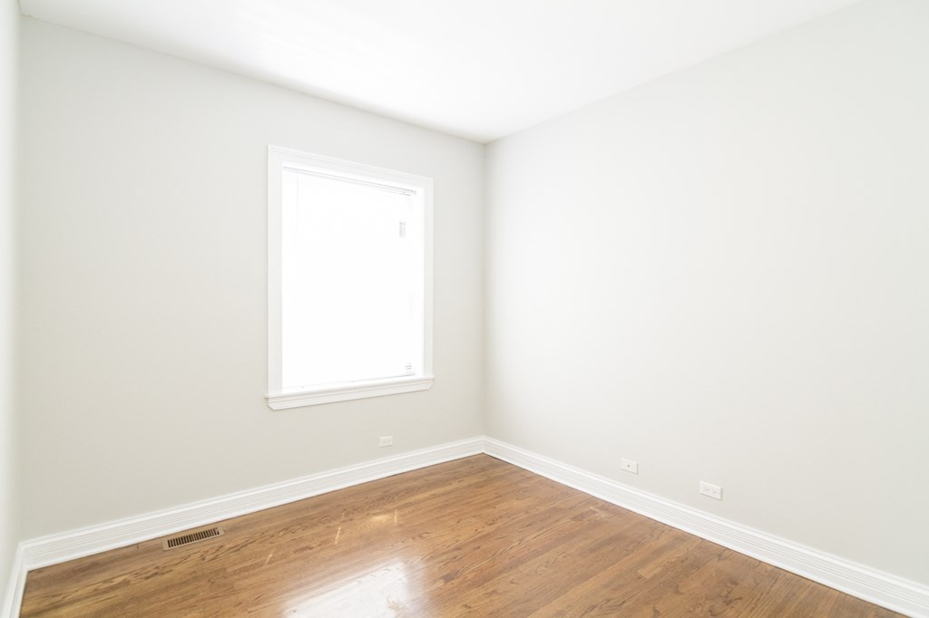 an empty room with white walls and a window
