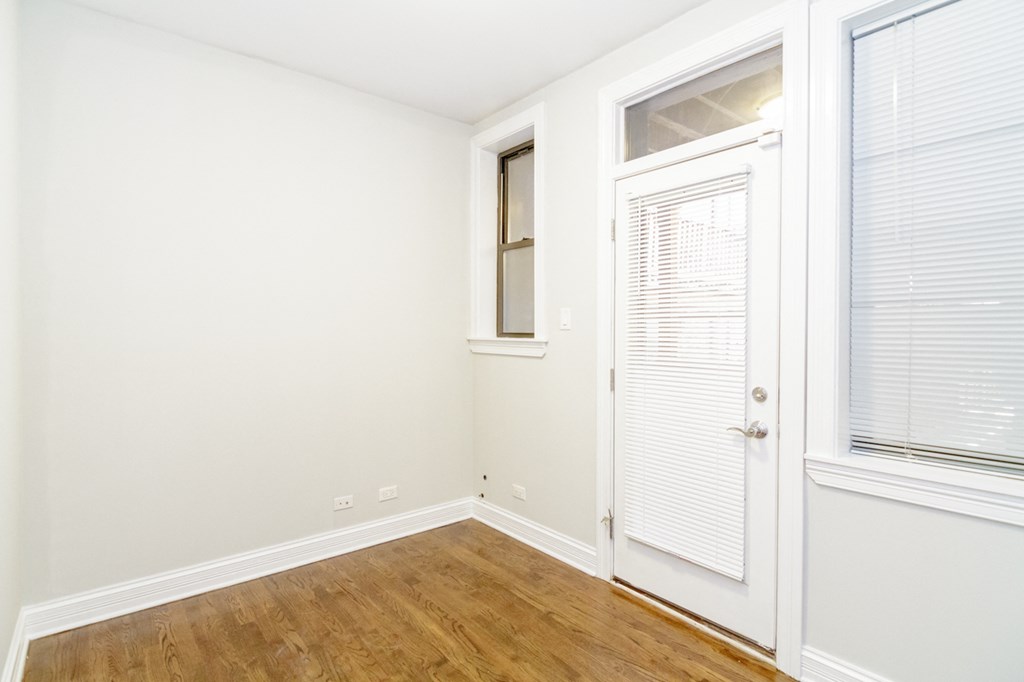 a bedroom with a door and a window and a wood floor