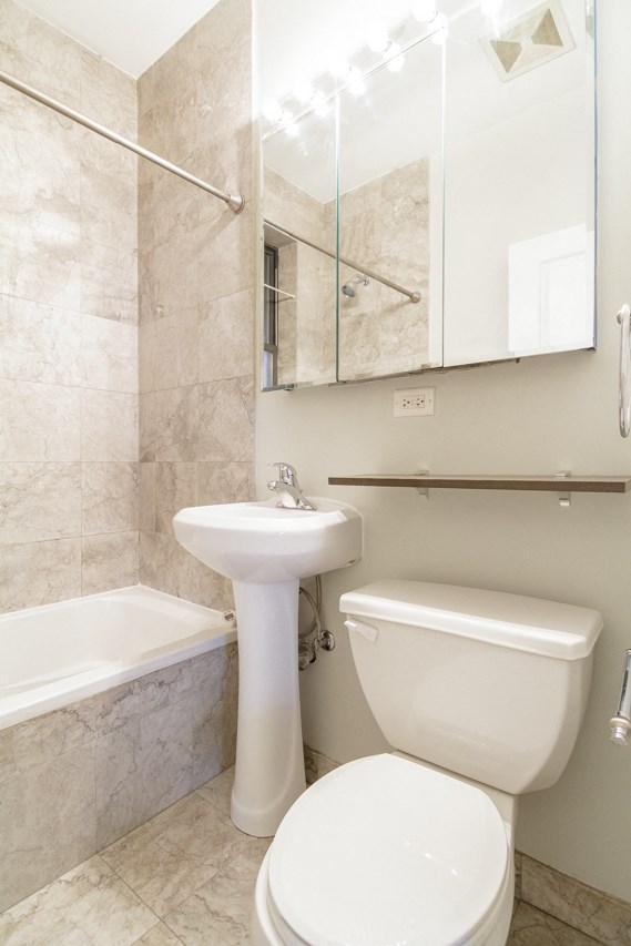 a bathroom with a toilet and a sink and a tub