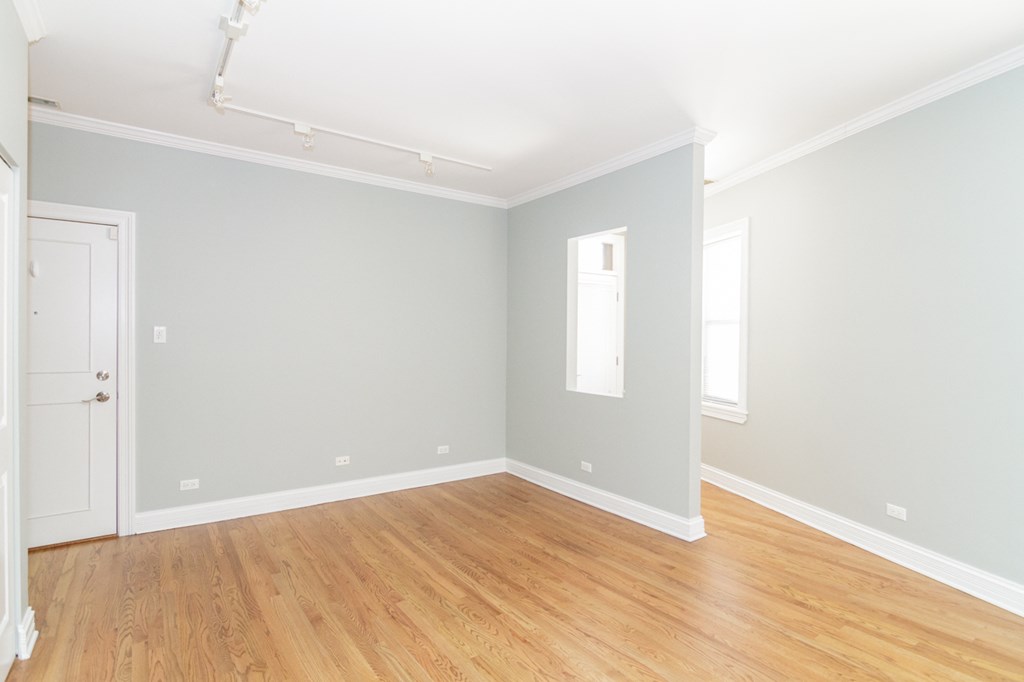 an empty room with wood floors and a white door