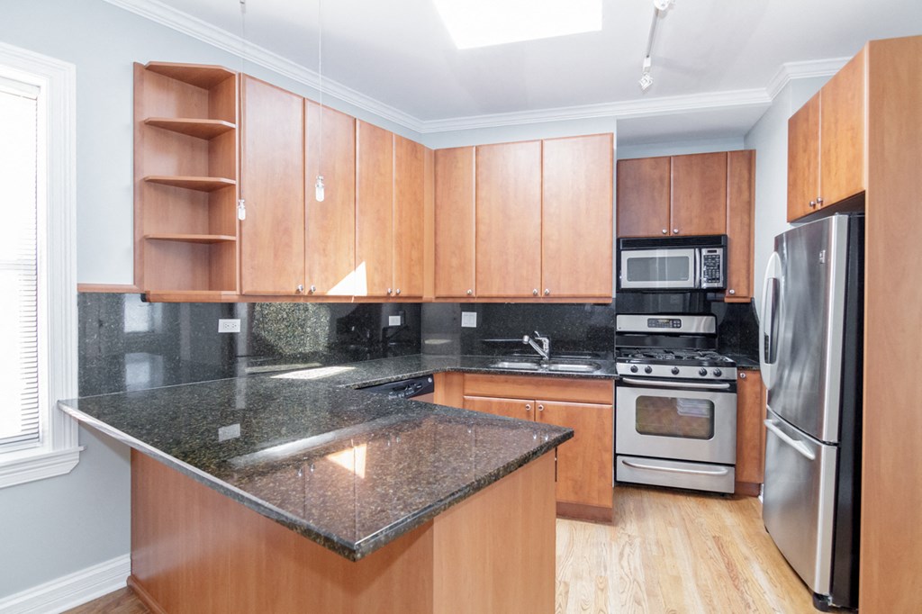a kitchen with wooden cabinets and granite counter tops and stainless steel appliances