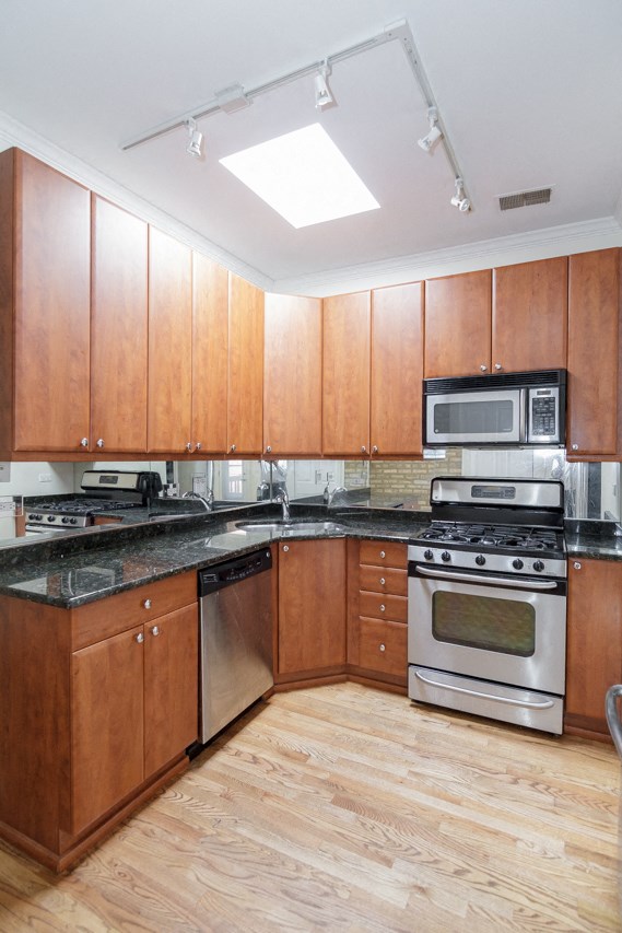 a kitchen with wooden cabinets and stainless steel appliances