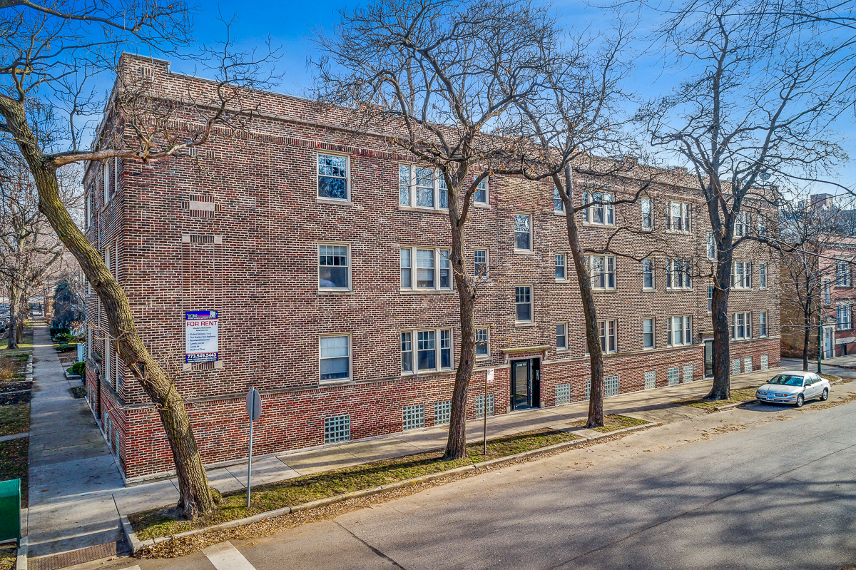 a large brick building with a car parked in front of it