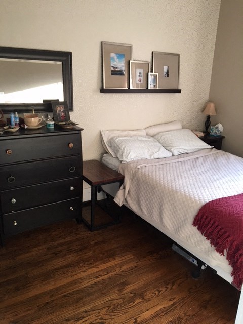 a bedroom with a bed and a dresser and a mirror
