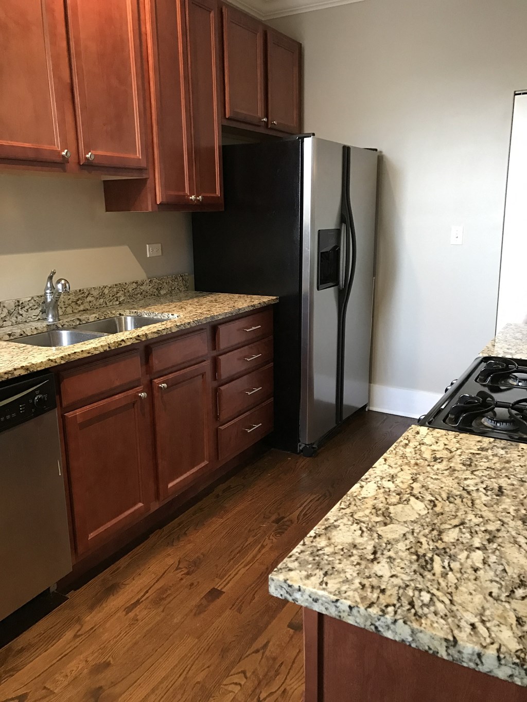 a kitchen with granite counter tops and a stainless steel refrigerator