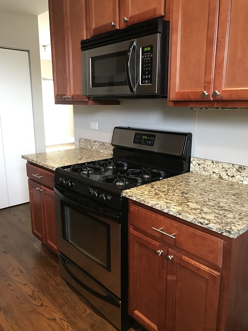 a kitchen with granite counter tops and a stove and microwave
