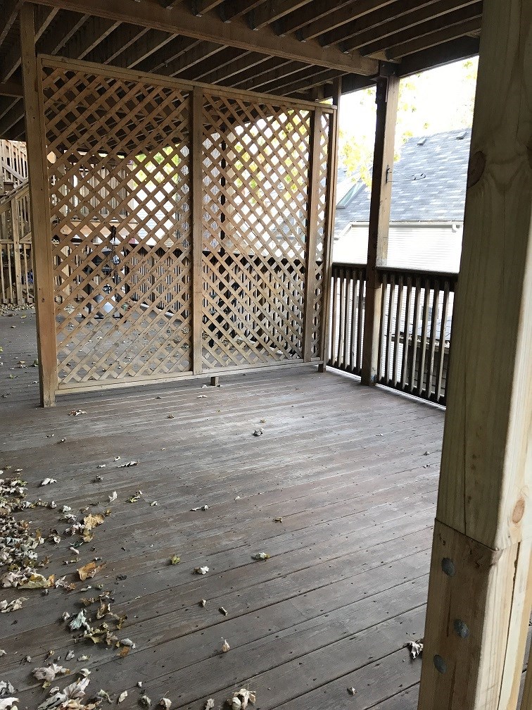 a view of a screened porch with wood flooring and a latticed wall