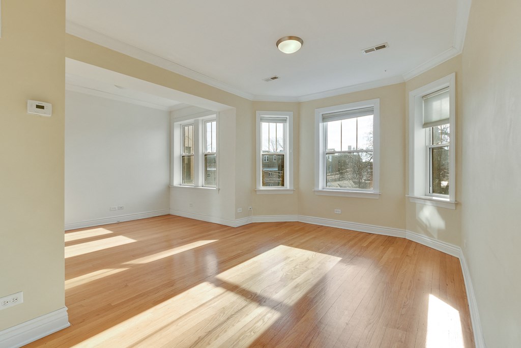 an empty living room with wood floors and windows