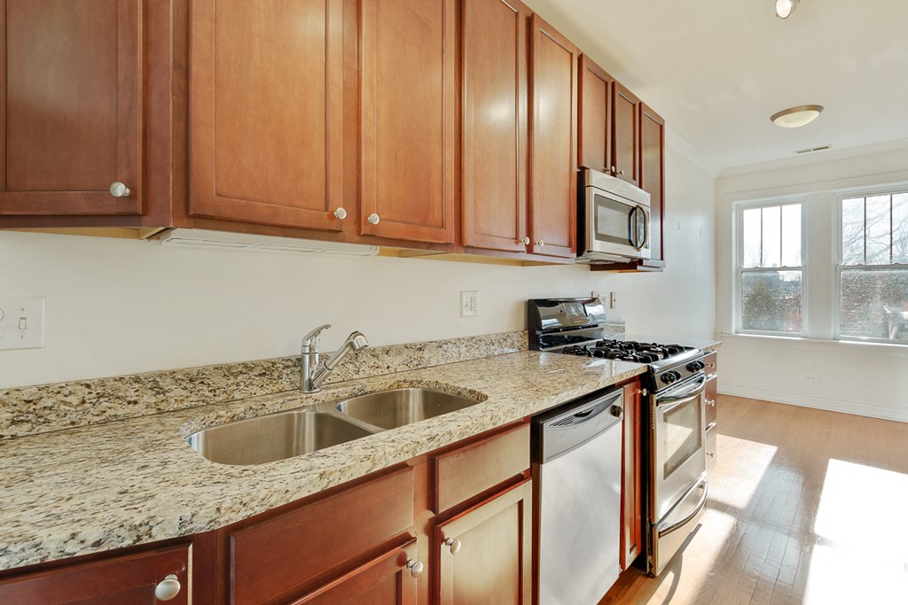 a kitchen with granite counter tops and wooden cabinets