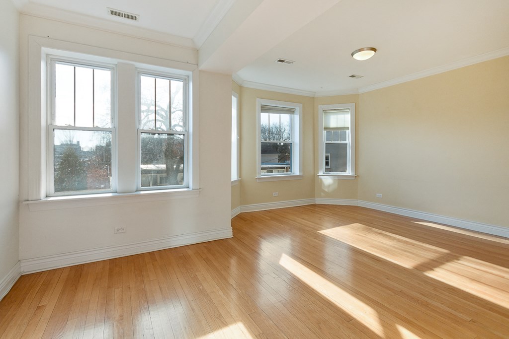 an empty living room with wood floors and windows