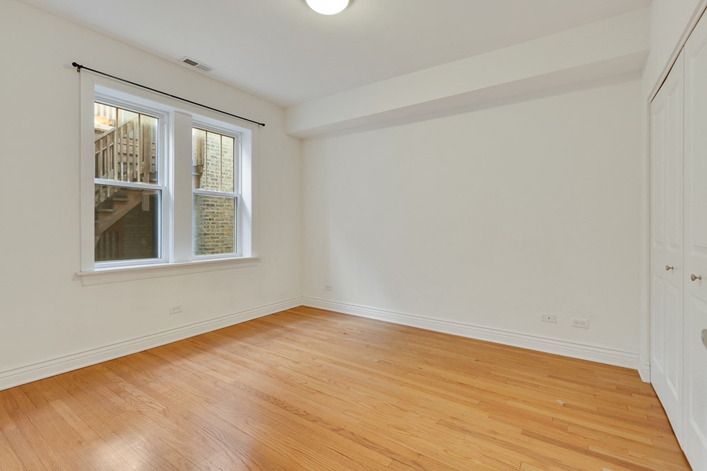 an empty room with wood floors and a window