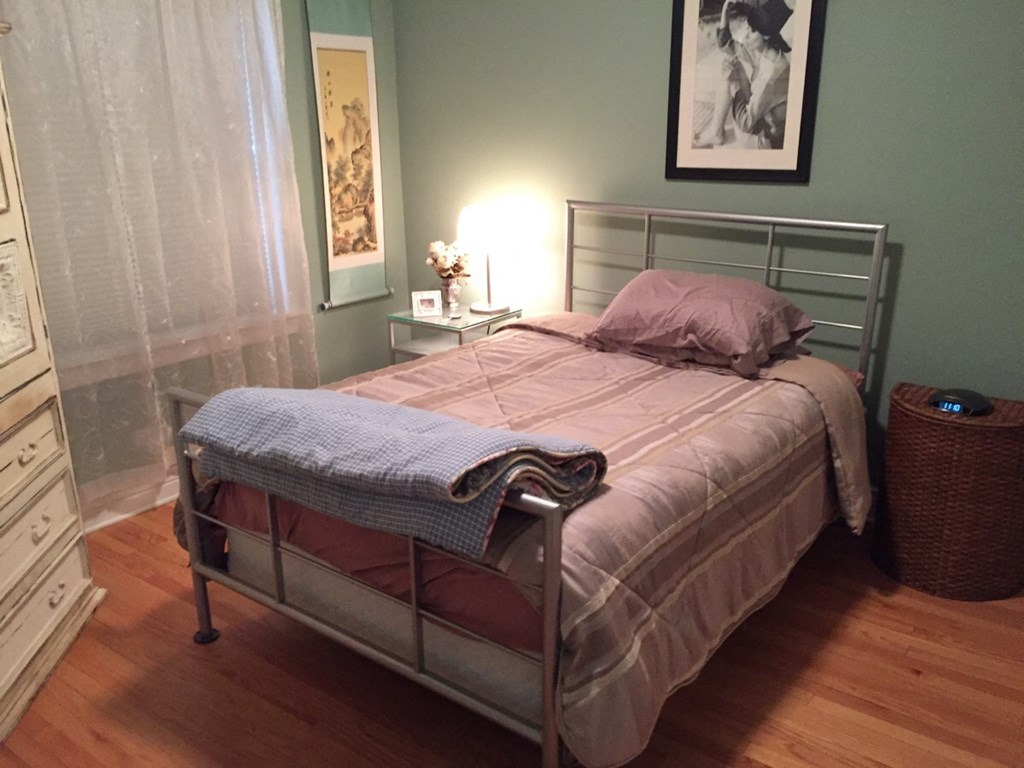 a small bedroom with a bed and a night stand