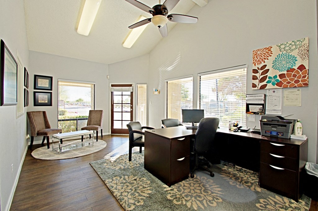 a home office with a desk and a ceiling fan