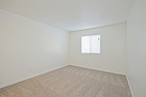 an empty room with carpet and a window