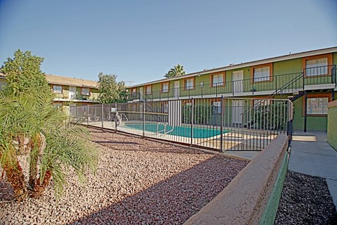 an apartment building with a pool and a fence