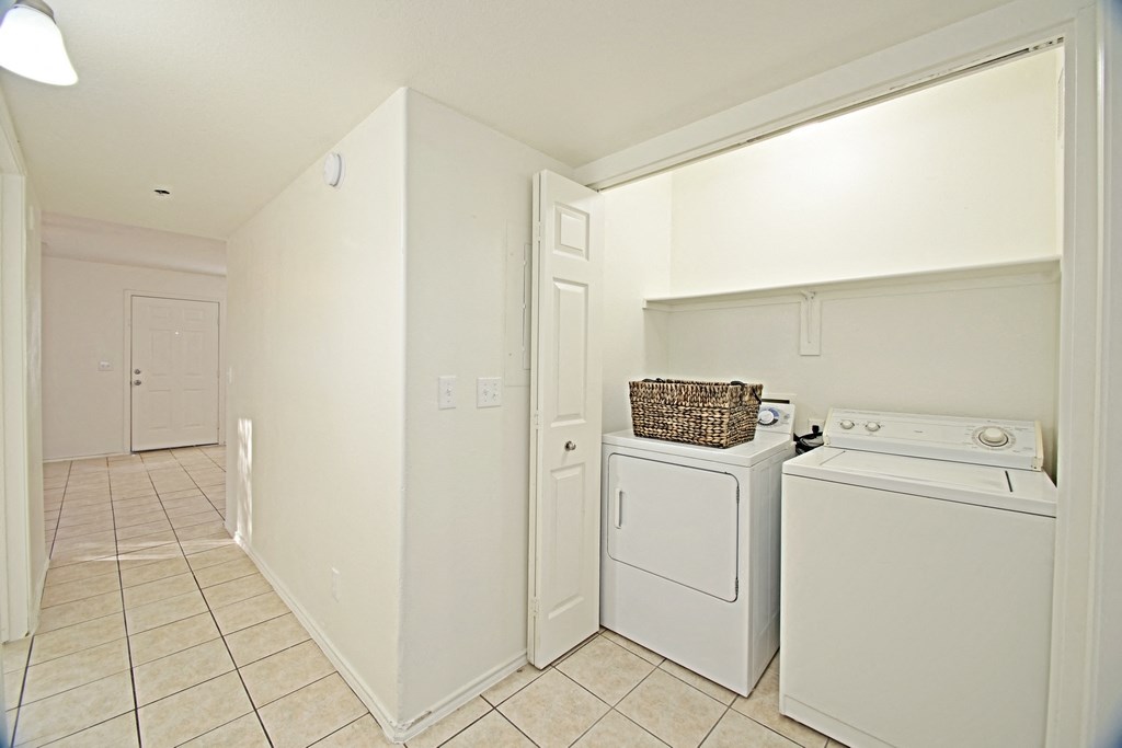 a laundry room with a washer and dryer and a door to a closet