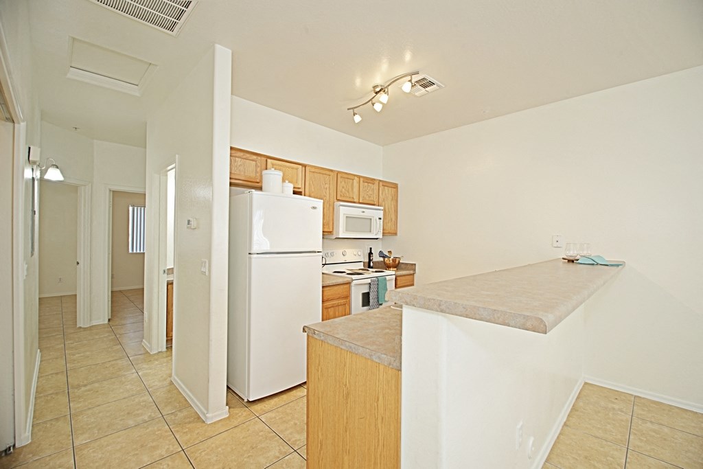 a view of a kitchen with a counter top and a refrigerator