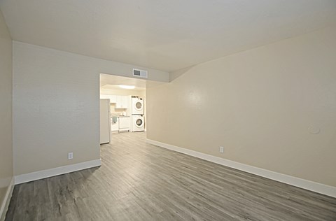 an empty living room with white walls and wood flooring
