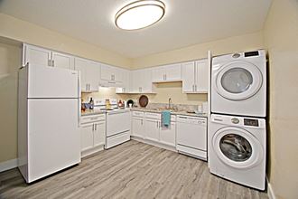 a white kitchen with a washing machine and a dryer in it