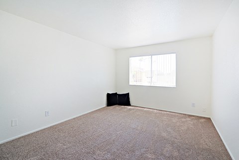an empty room with carpet and a window