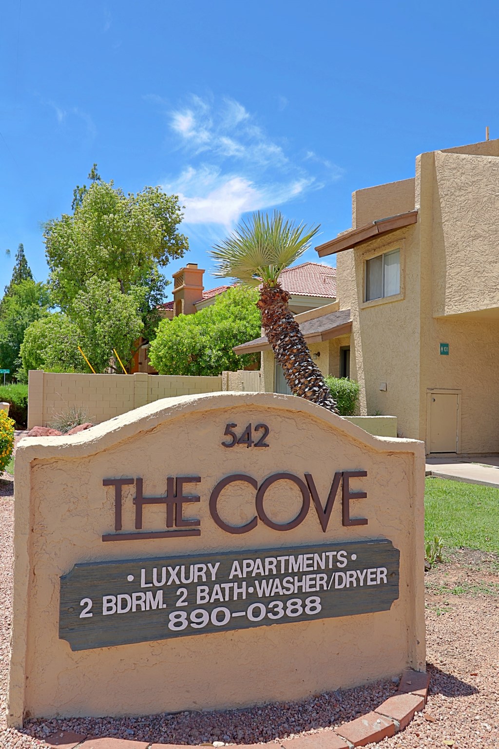 the condo sign in front of a house with a palm tree