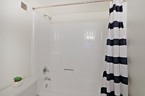 a white bathroom with a black and white shower curtain