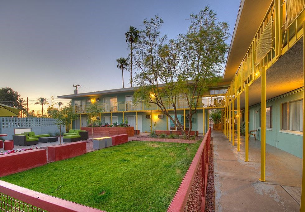 a building with a green lawn and a courtyard