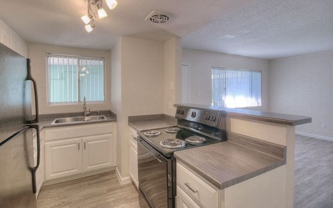 an empty kitchen with a stove and a sink