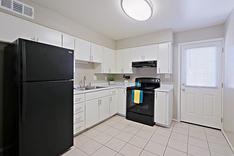 a kitchen with black appliances and white cabinets