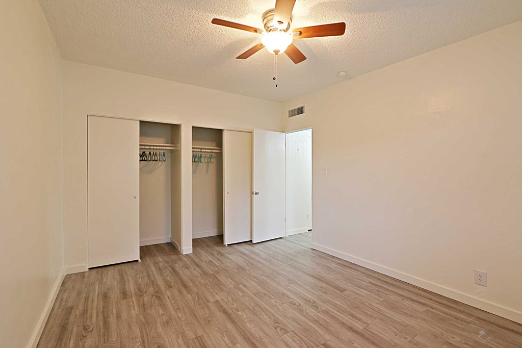 a living room with a ceiling fan and closet