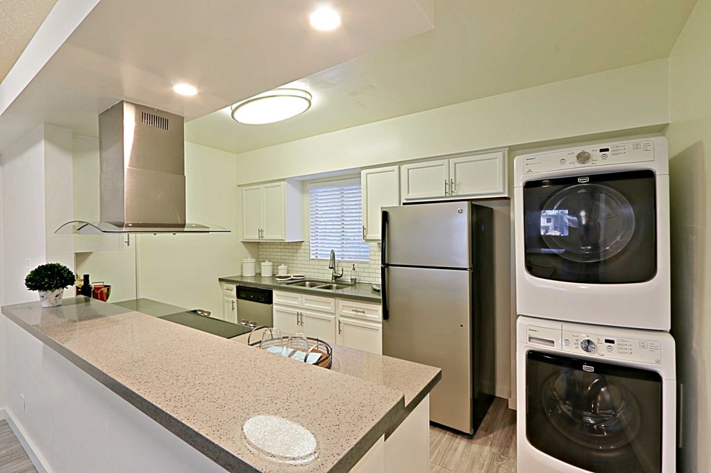 a kitchen with a washer and dryer and a sink