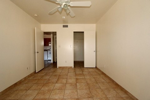 the living room has a ceiling fan and a tiled floor