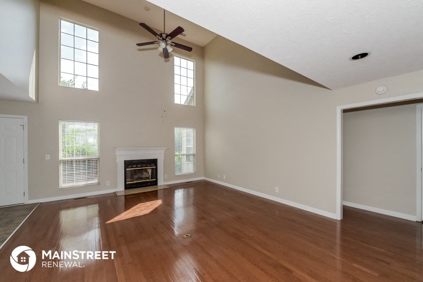 the living room with wood flooring and a fireplace