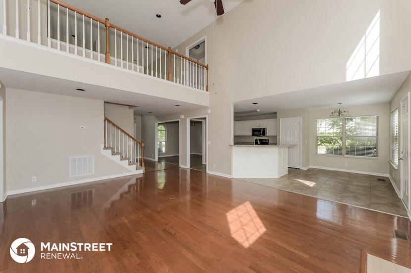 the spacious living room and kitchen in this renovated home