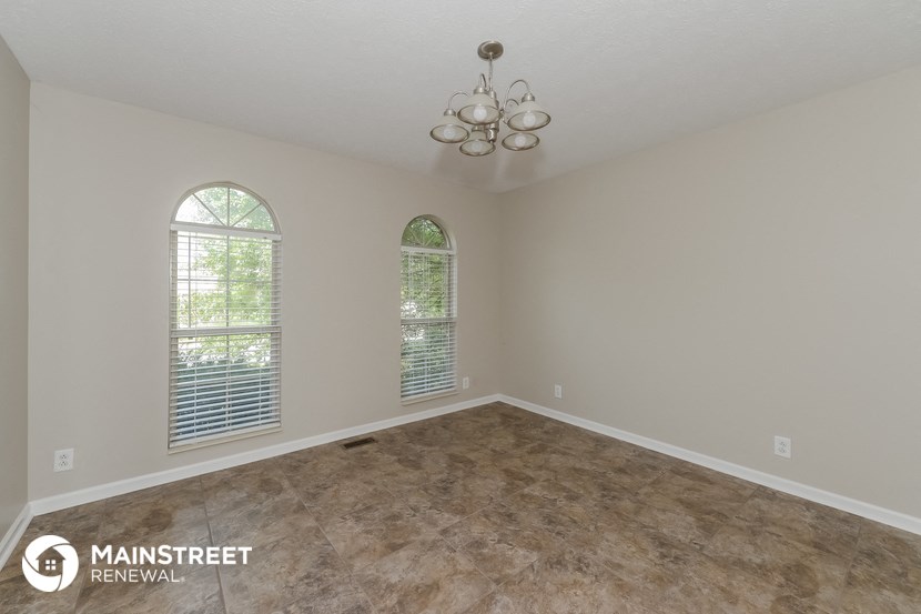 the spacious living room with vinyl flooring and two windows