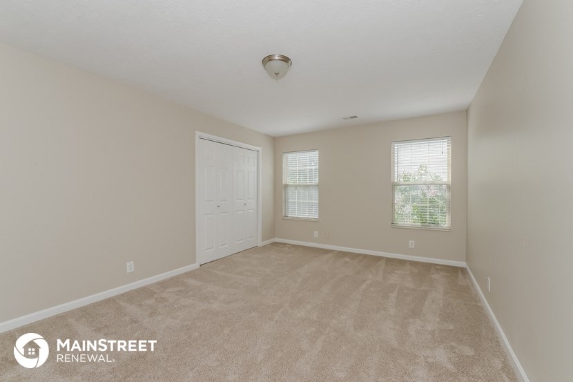 the spacious living room with carpeting and a white door